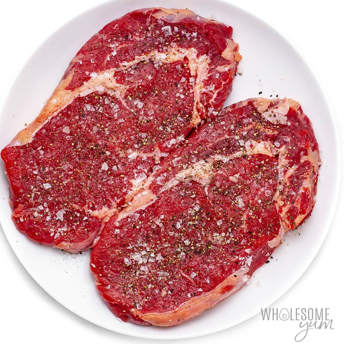 Seasoned steak on a plate.