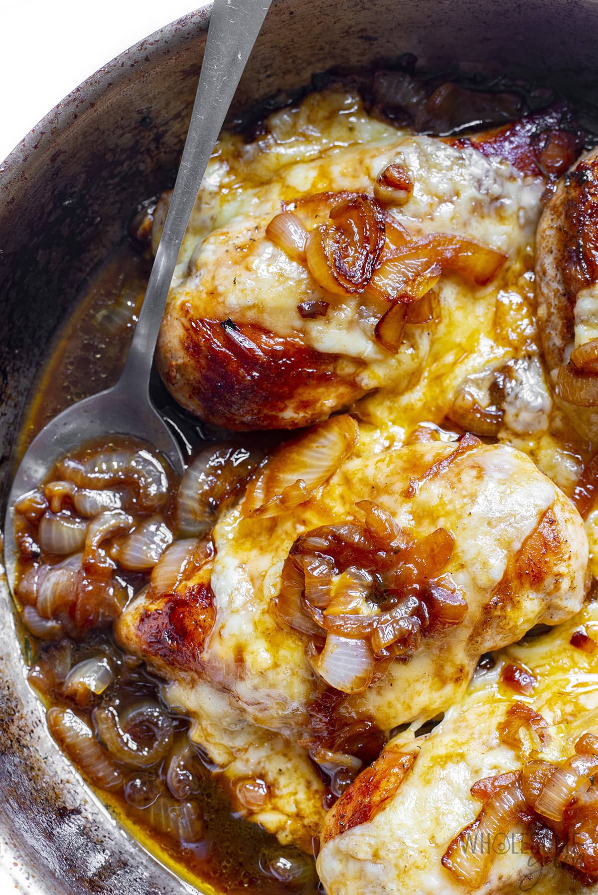 Fully cooked French Onion Chicken baked in a pan.
