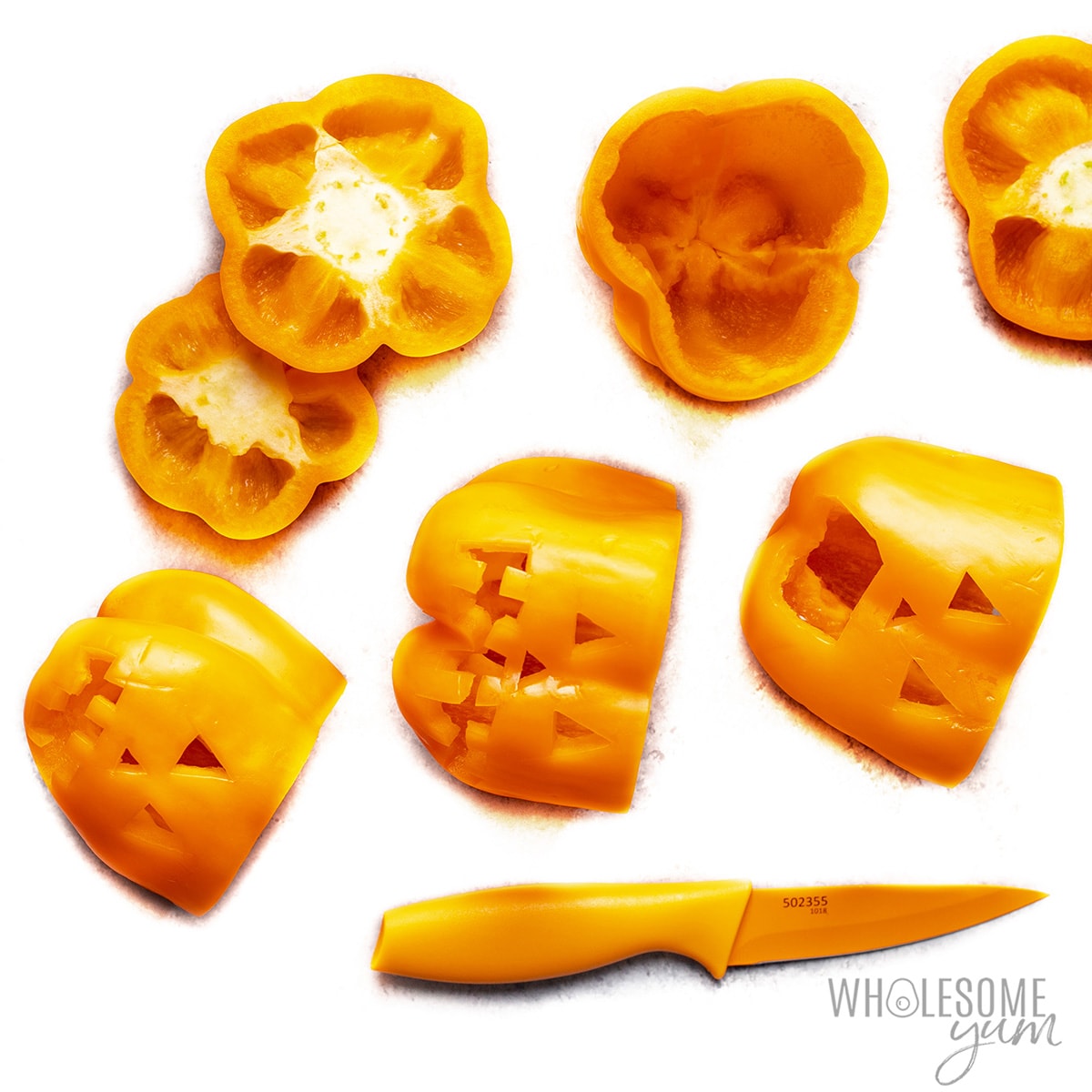 Orange bell peppers with jack-o-lantern faces cut out.