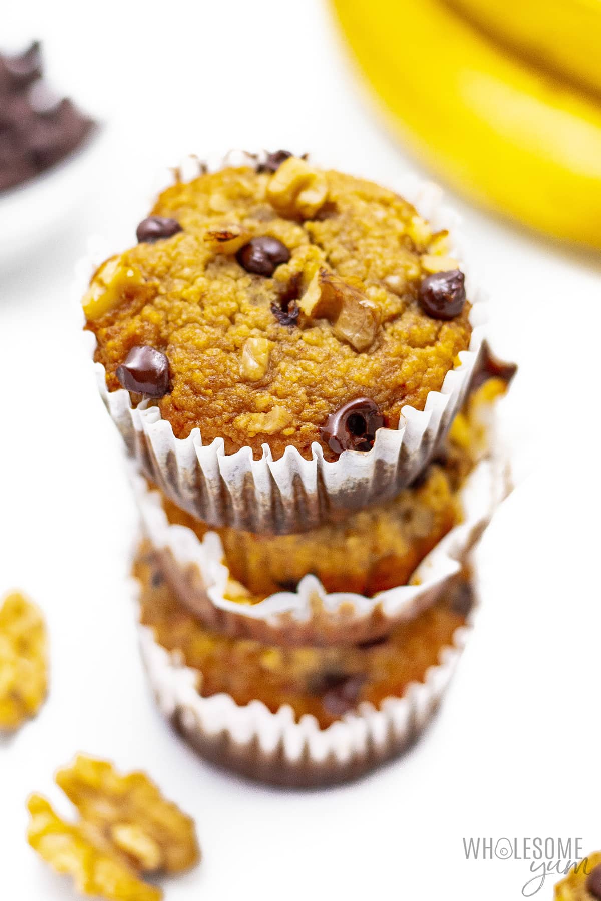 Healthy banana muffins with bananas in the background.