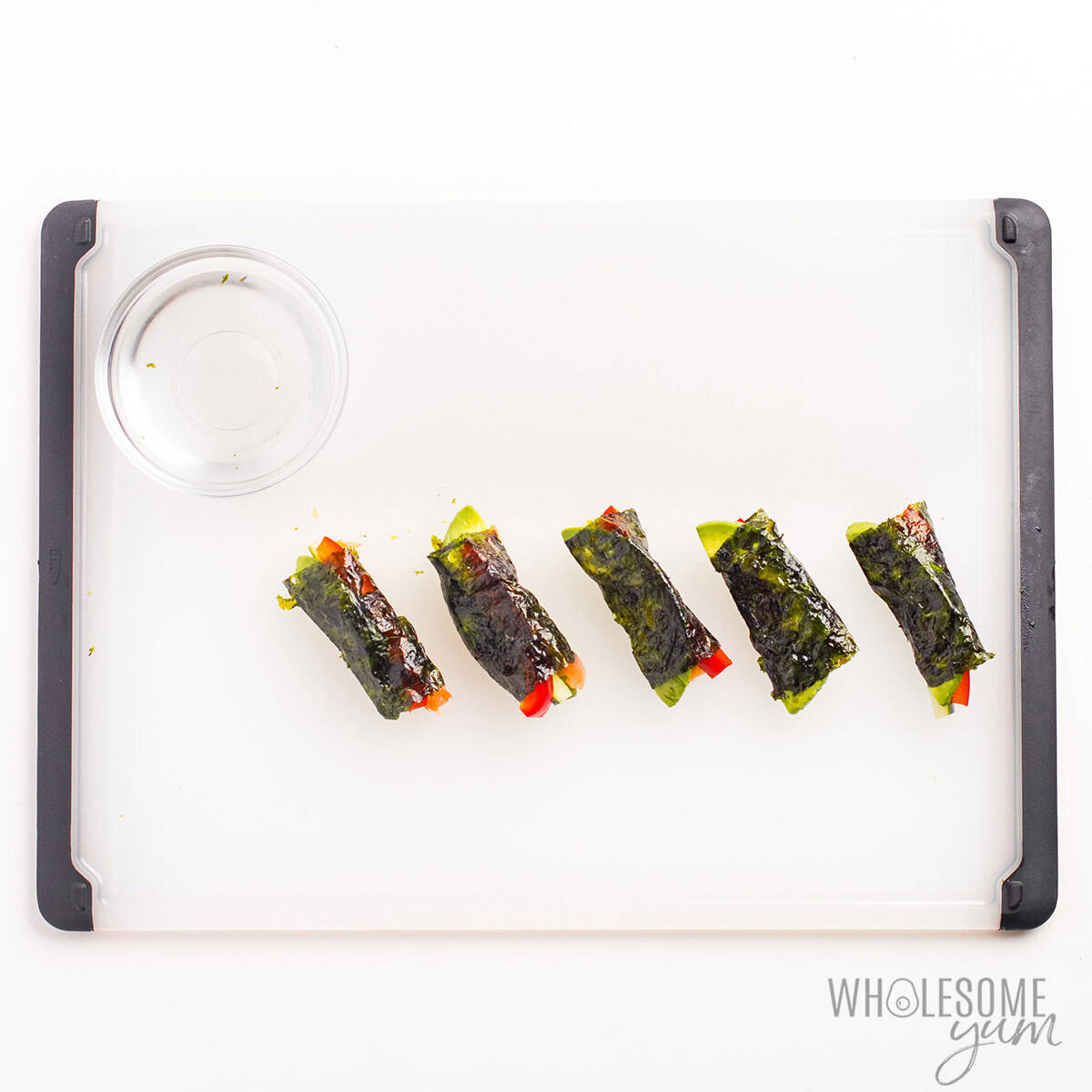 Keto sushi rolls sealed on a cutting board.