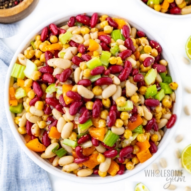 Three bean salad recipe in a bowl with ingredients on the sides.