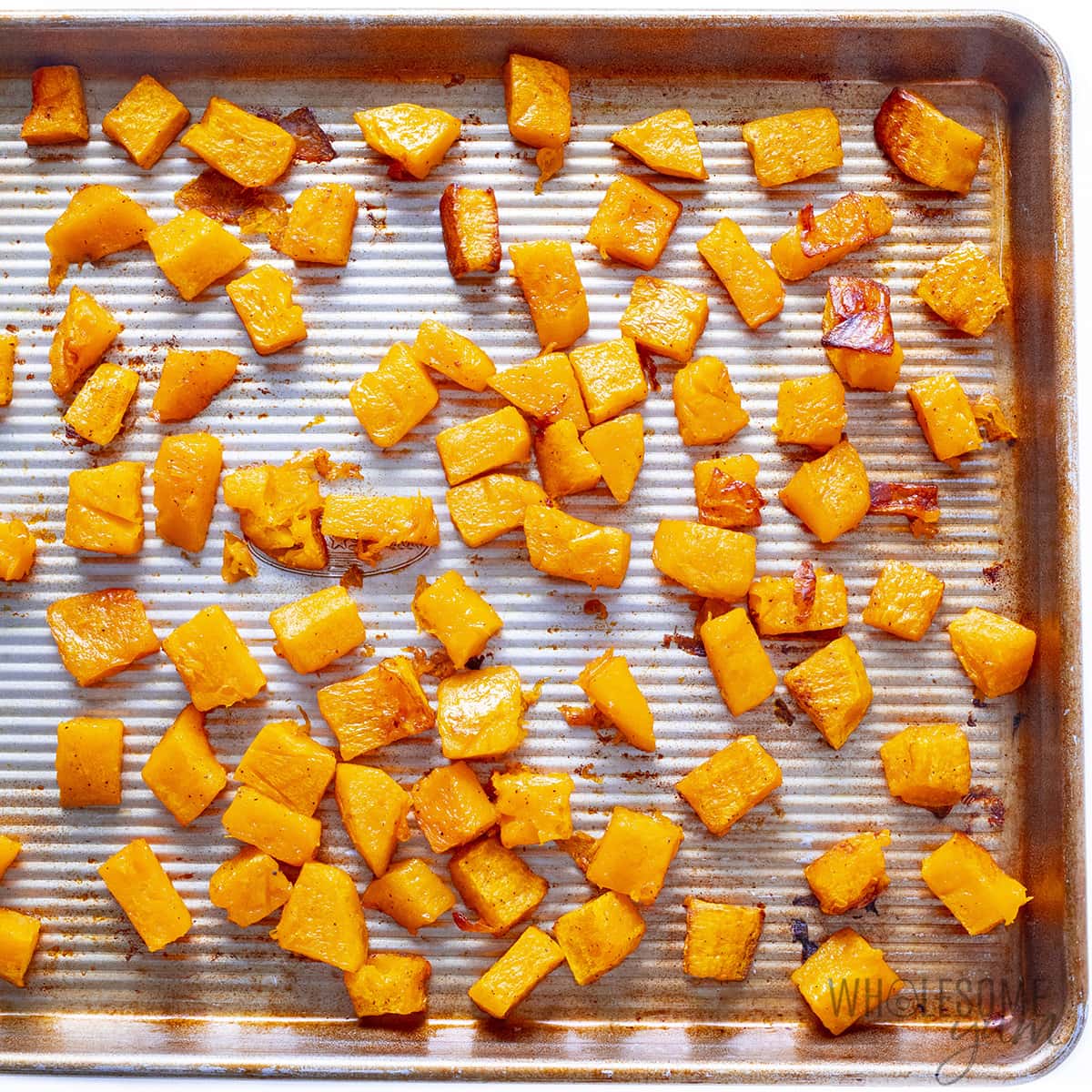 Roasted butternut squash on a baking pan.