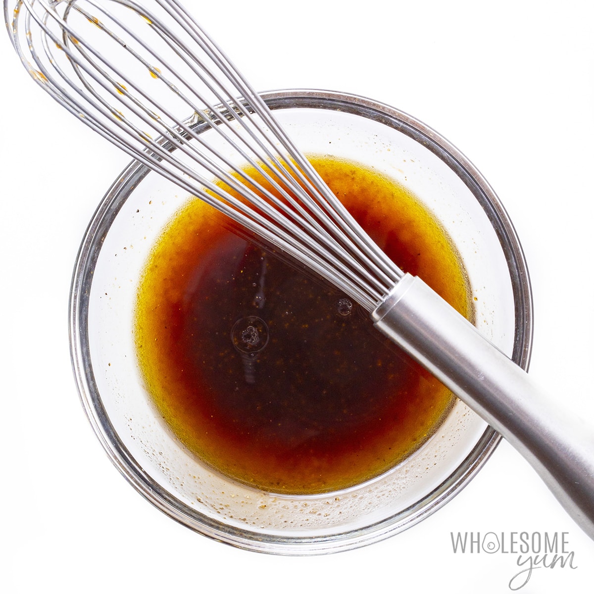 Butternut squash salad dressing in a bowl with whisk.
