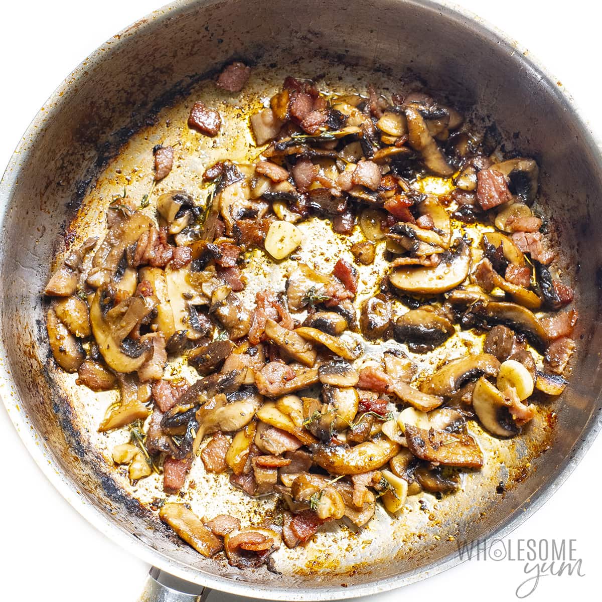 Mushrooms, bacon, and seasonings in a skillet.