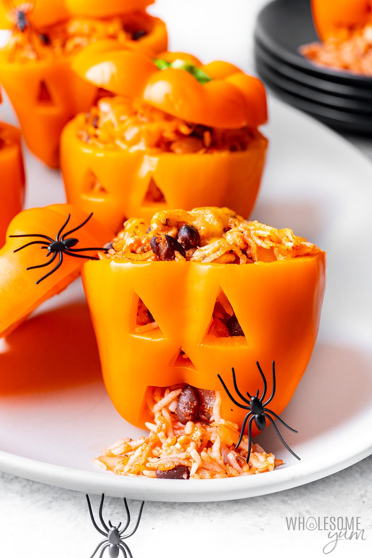 Halloween stuffed peppers with rice coming out of the mouth.