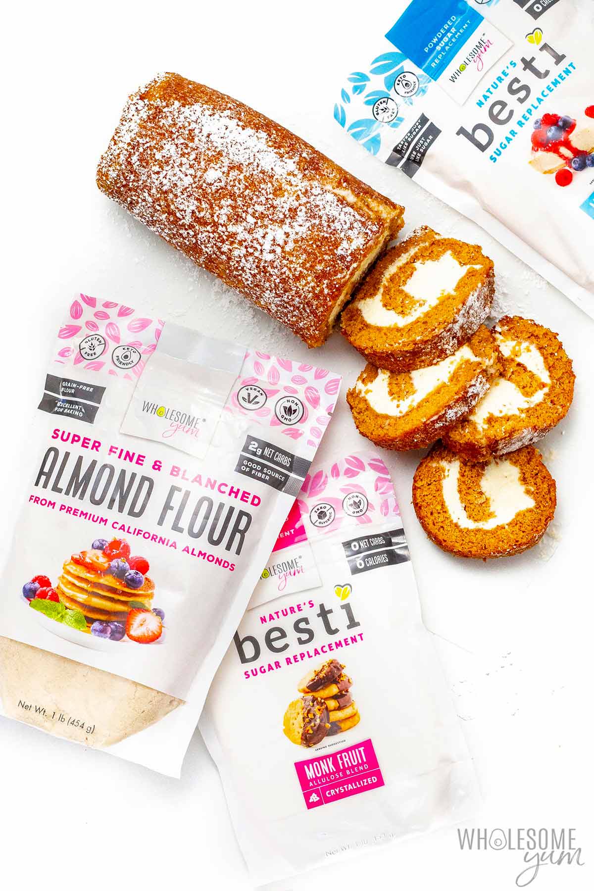 Keto pumpkin roll next to bags of Besti and Wholesome Yum Almond Flour..