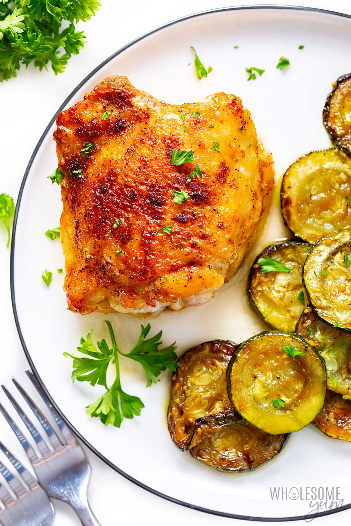 Plated pan seared chicken thigh recipe with zucchini.