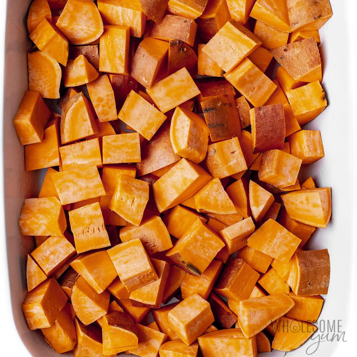 Evenly layered sweet potatoes in baking dish. 