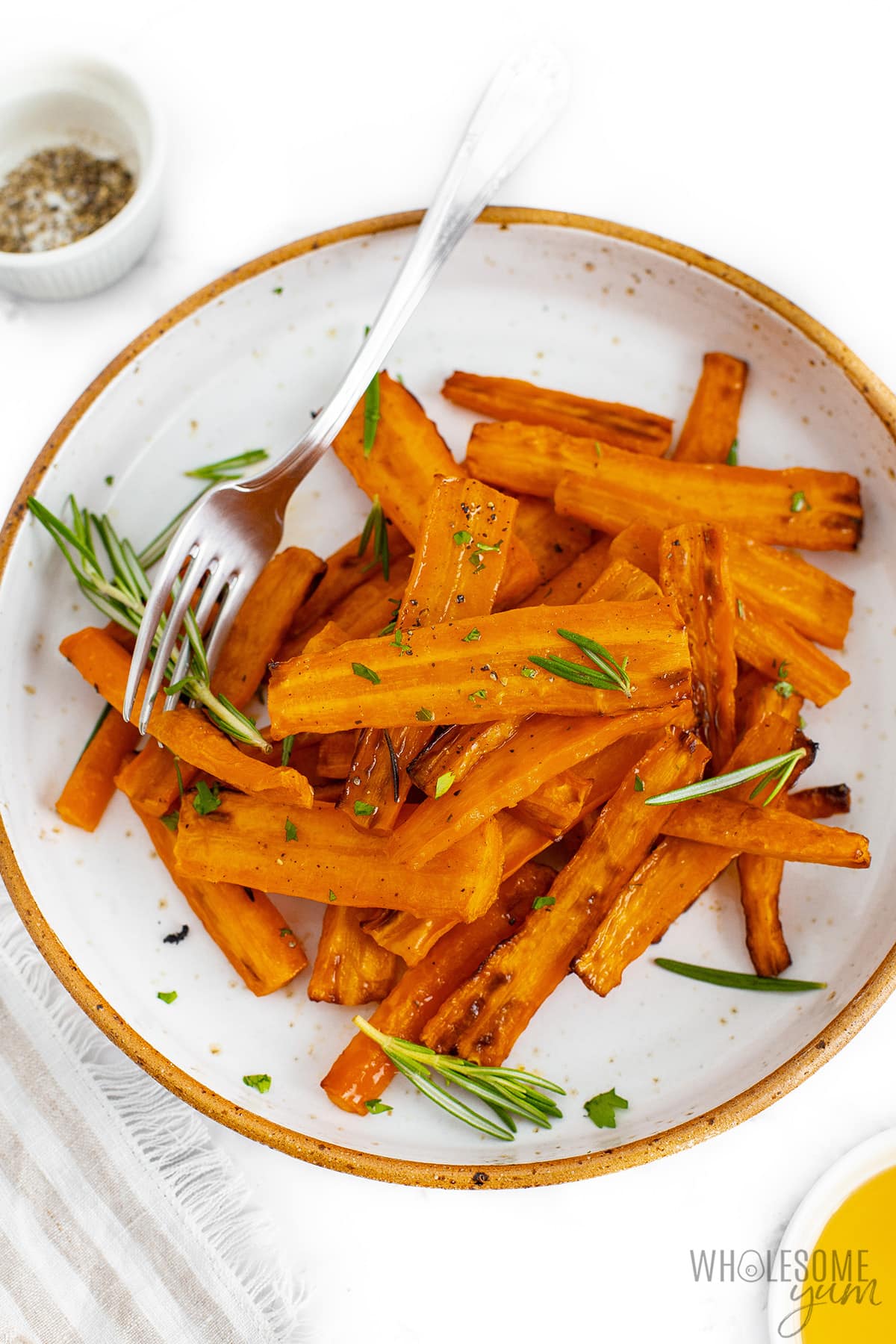 Air fryer carrots on a plate with a fork.