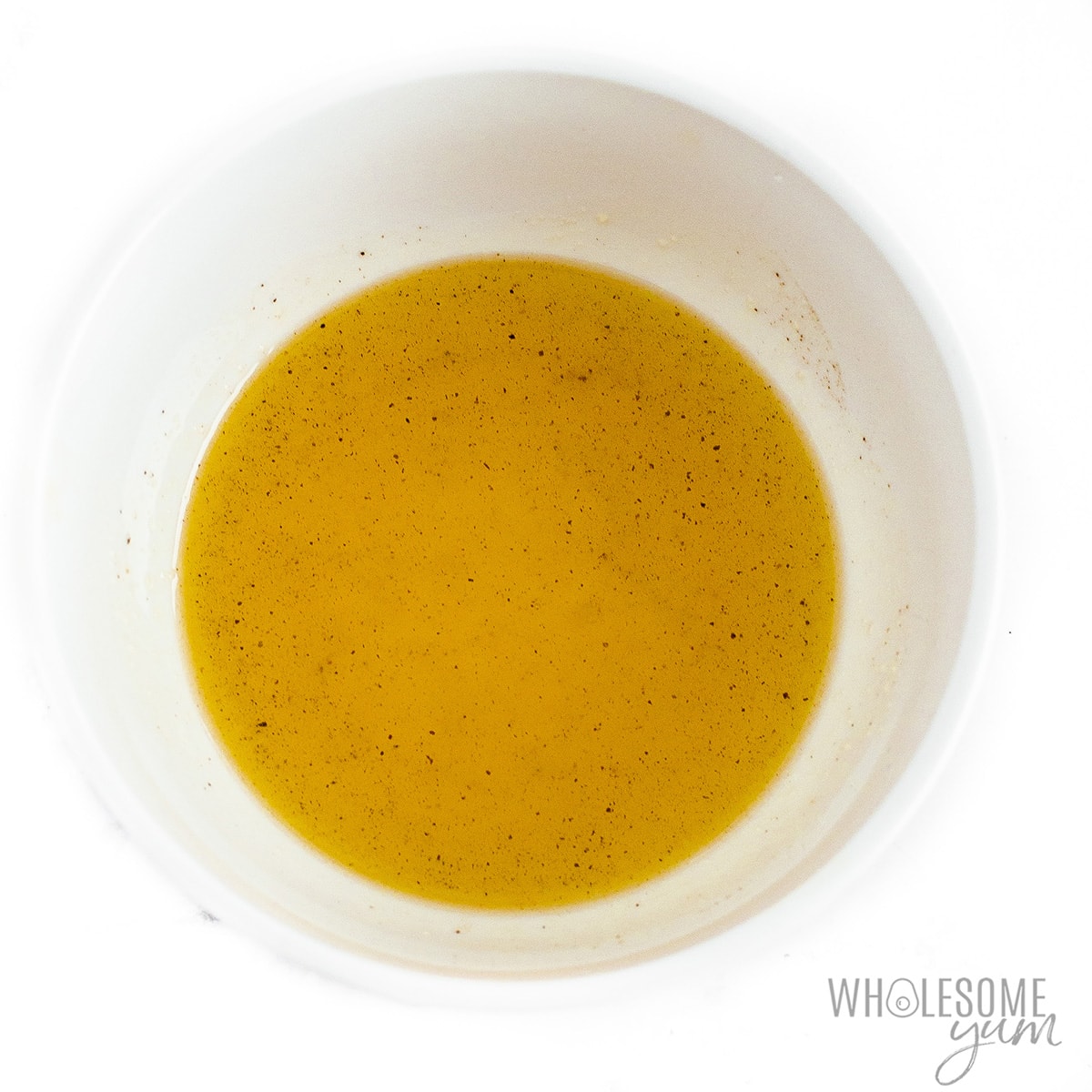 Miel, aceite de oliva, romero, sal y pimienta en un bol.