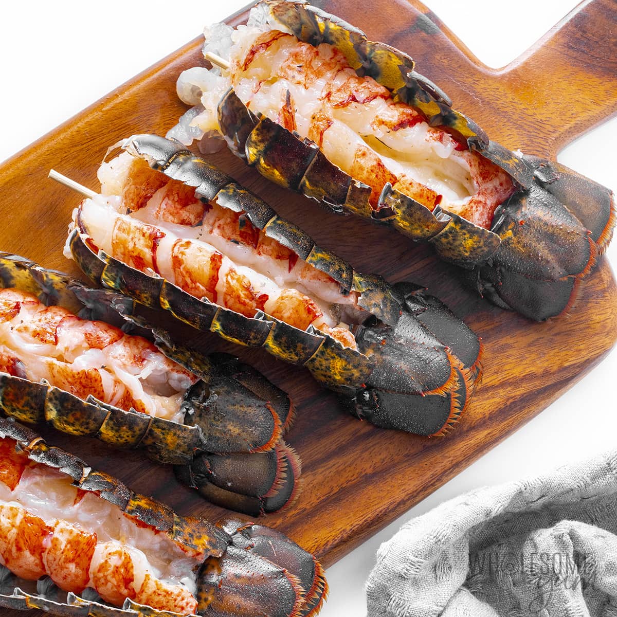 Bamboos skewers run through the meat of lobster tails.