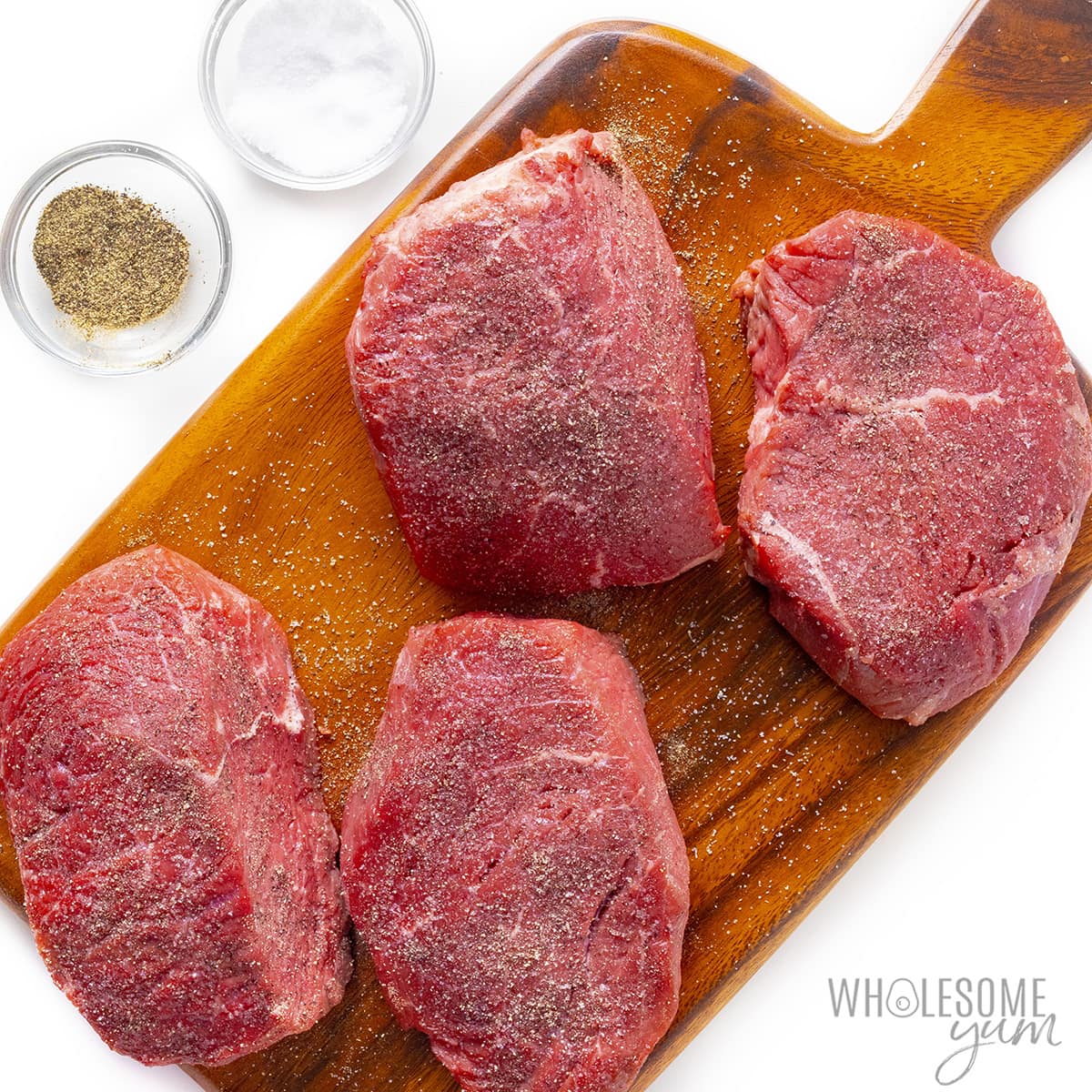 Seasoned steak on cutting board.