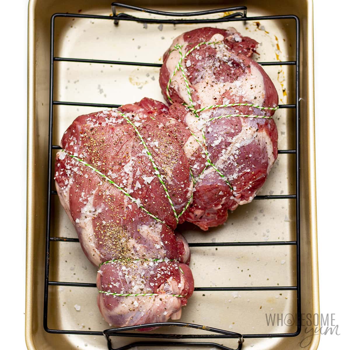 Tied up lamb in a roasting pan.