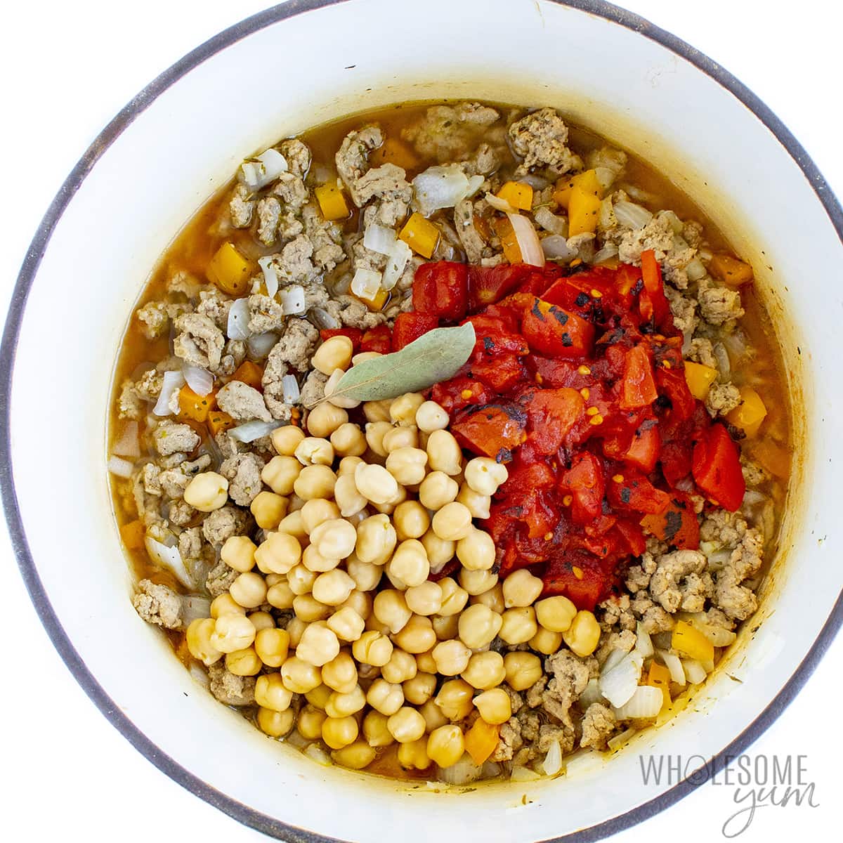 Roasted tomatoes and chickpeas are roasted with cooked turkey in a Dutch oven.