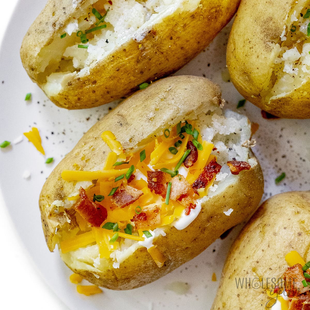 Instant Pot baked potatoes with toppings on a platter.