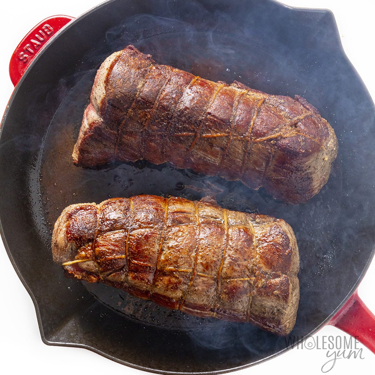 Seared beef tenderloin in cast iron skillet.
