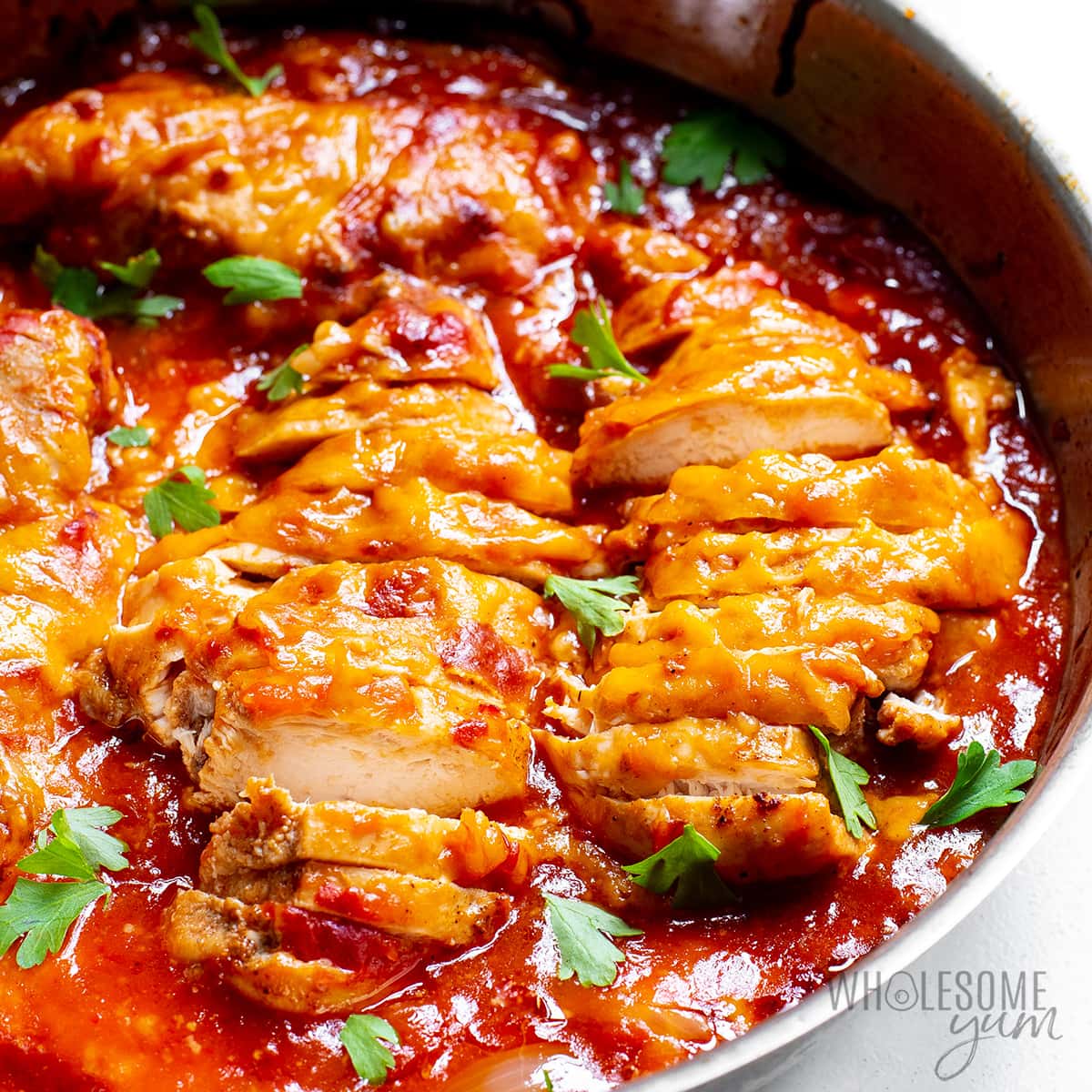 Baked salsa chicken recipe in a pan with parsley garnish.