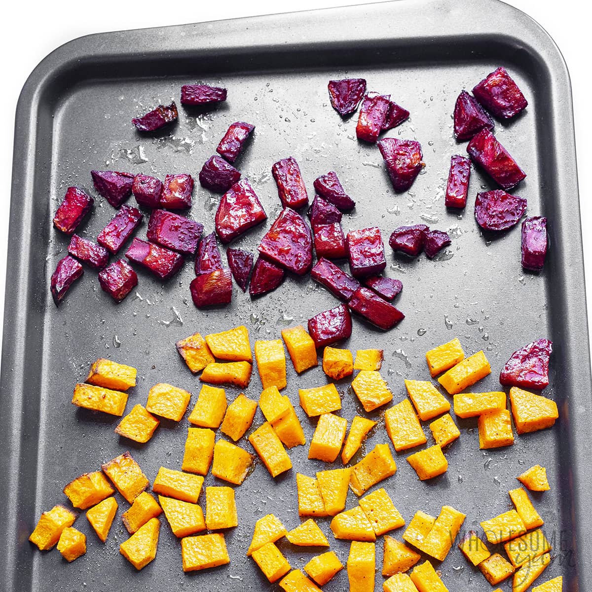 Roasted butternut squash and beets on a sheet pan.