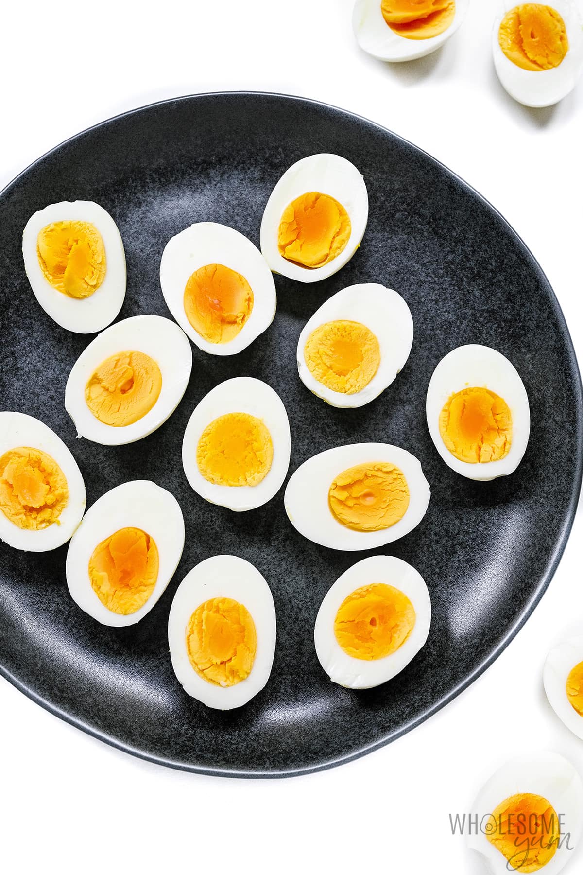 Air fried hard boiled eggs on a black plate.
