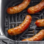 Air fryer sausages in a basket.