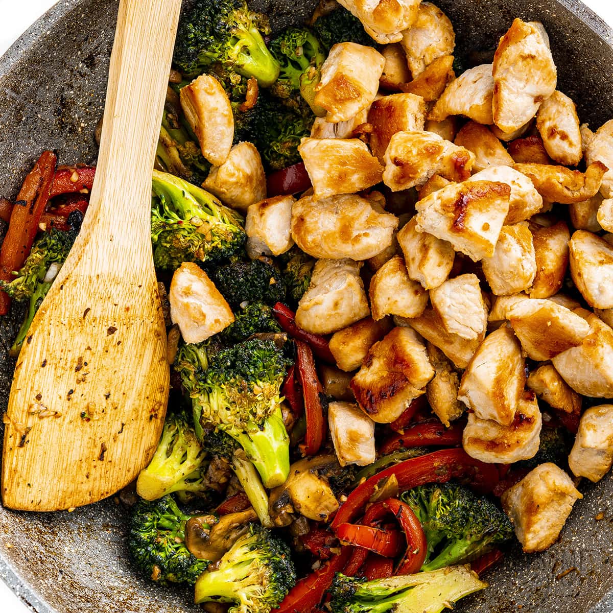 El pollo y las verduras se cocinan juntos en el wok.