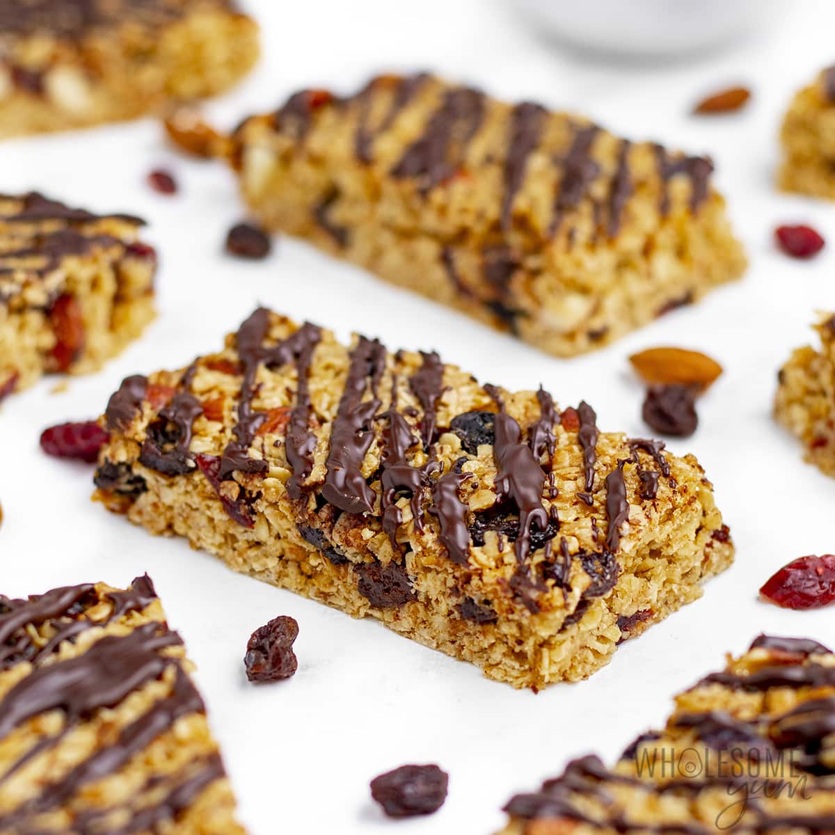 Sliced oatmeal bars recipe on parchment paper scattered with dried fruit.