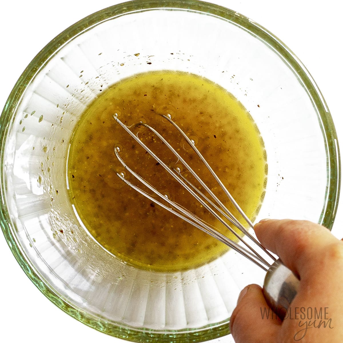 Dressing in a small bowl with a whisk.