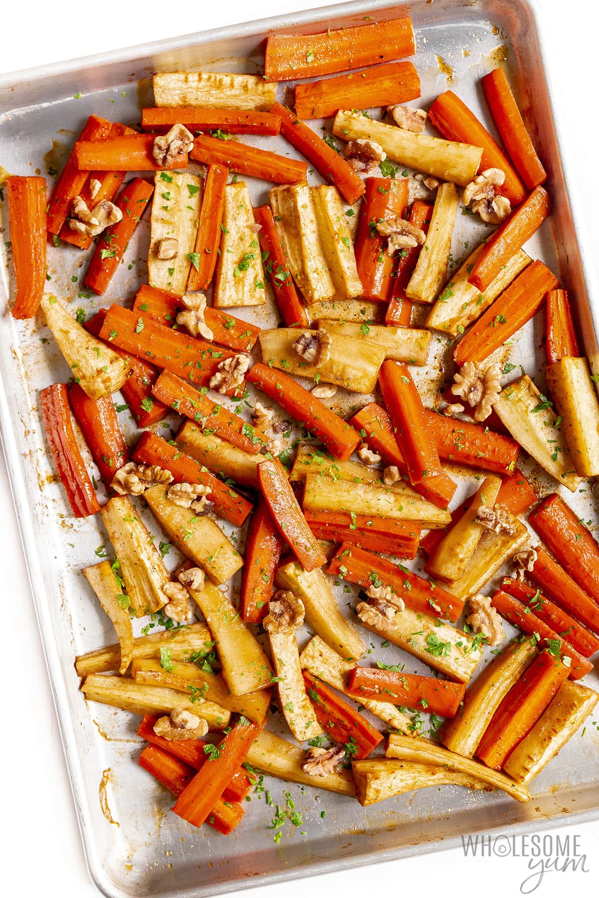 Roasted carrots and parsnips sprinkled with walnuts and parsley.