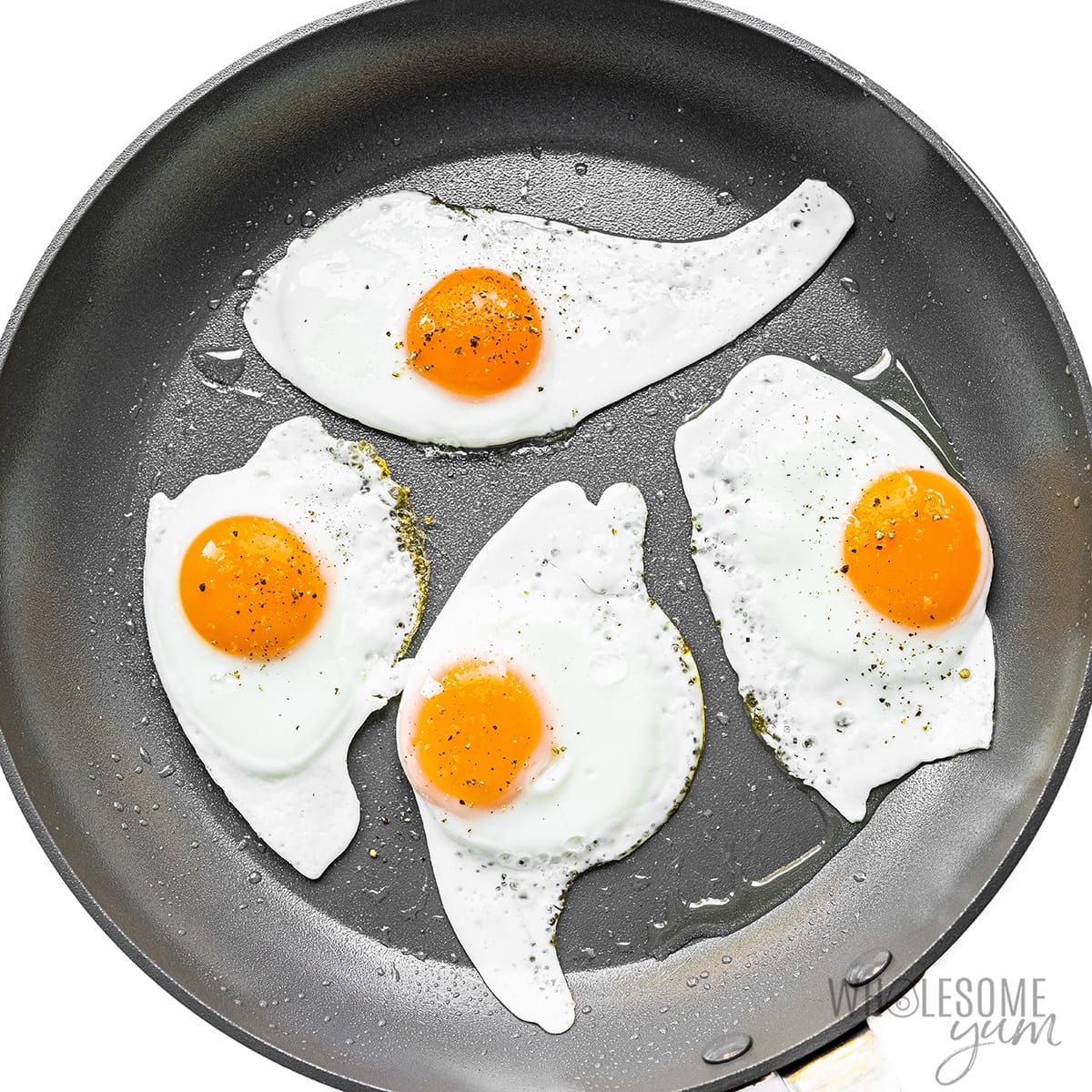 Four sunny side up eggs in non stick skillet. 