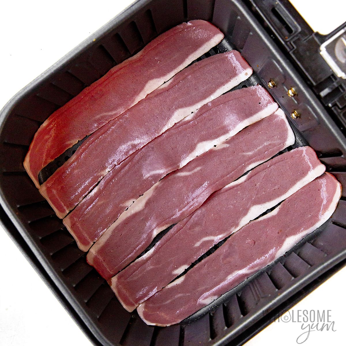 Raw turkey bacon in a fryer basket.