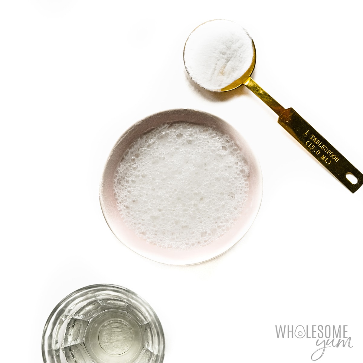 Vinegar in a glass next to baking soda.