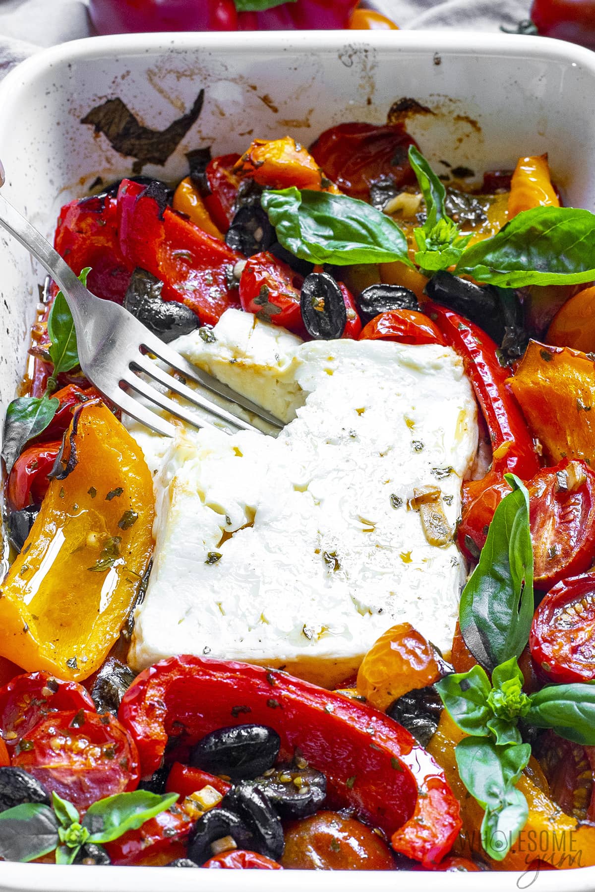 Baked feta is softened and pierced with a fork.