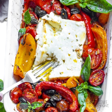 Baked feta recipe in baking dish with a fork.