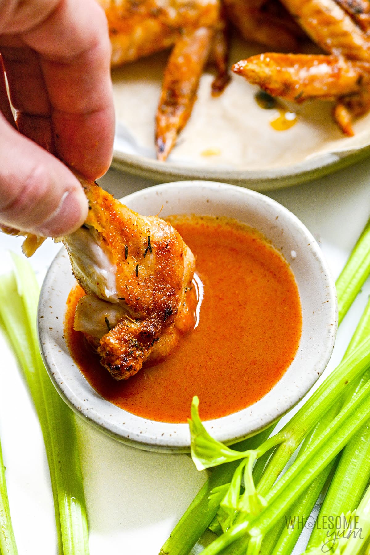 Whole chicken wings dipped in sauce.
