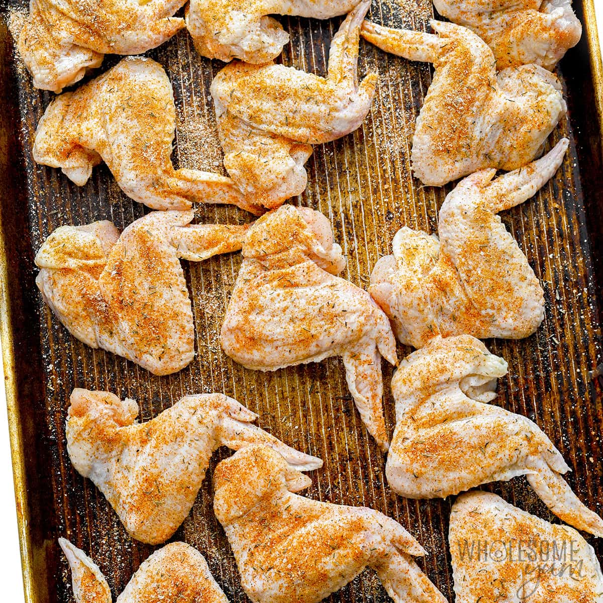 Raw chicken on baking sheet.