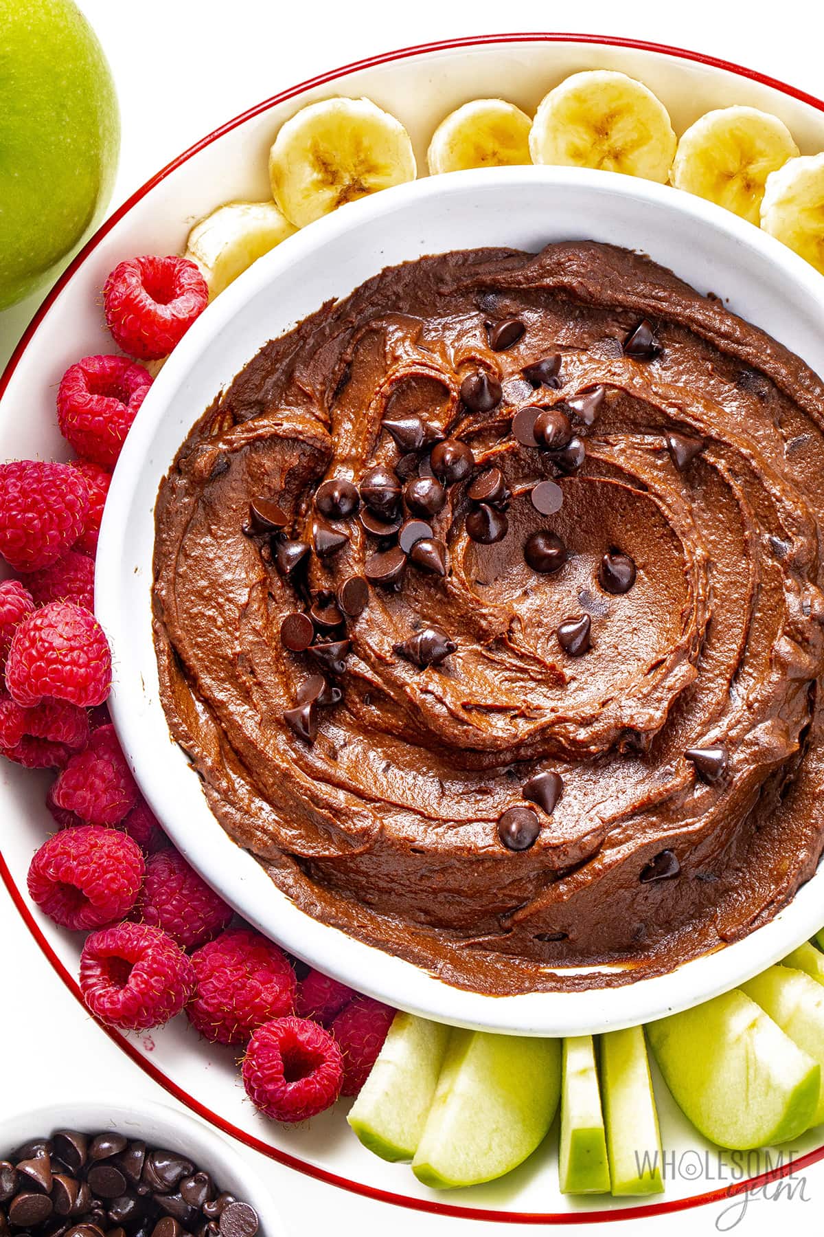 Bowl of chocolate hummus on a platter with fruit.