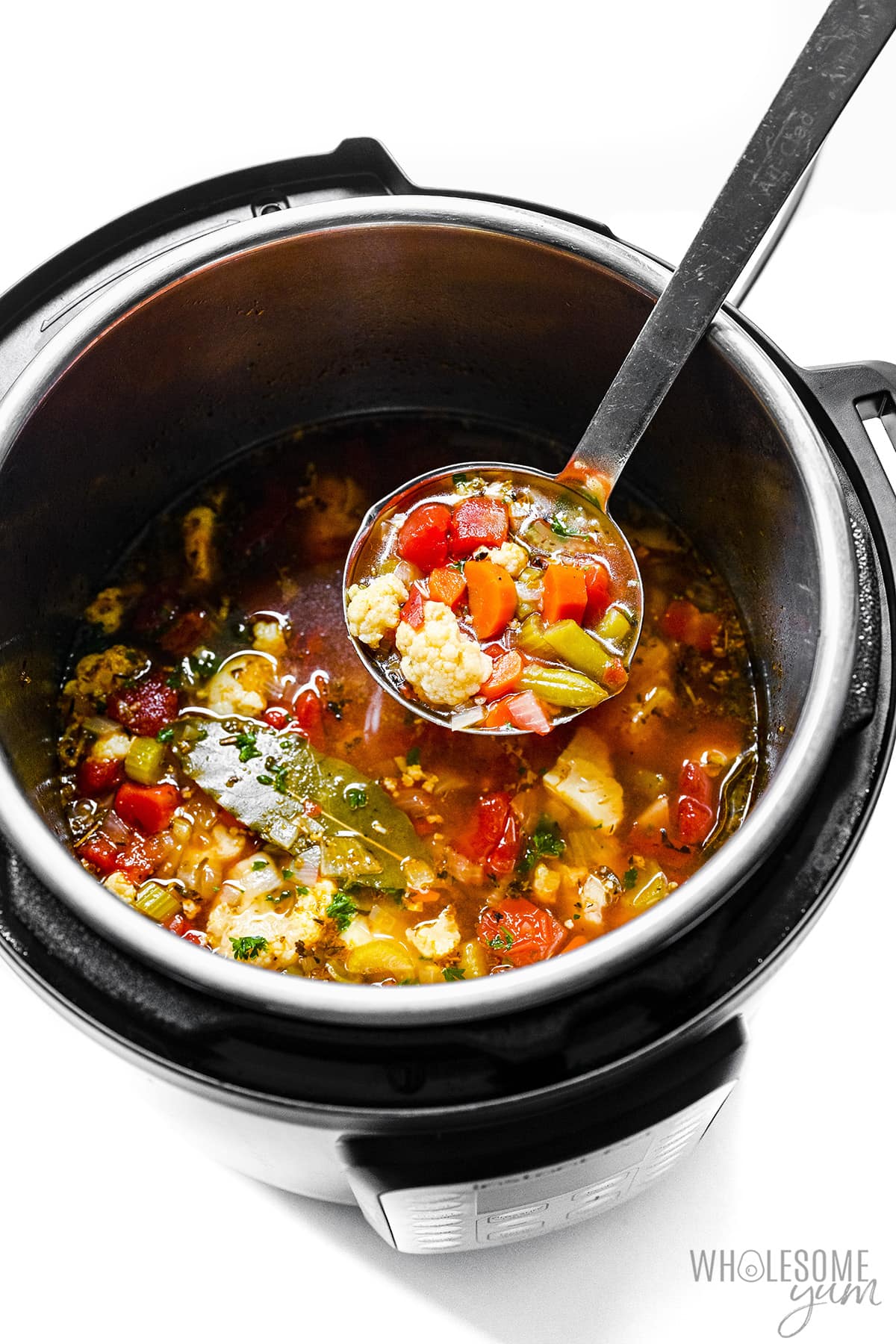 Instant Pot vegetable soup on a ladle.