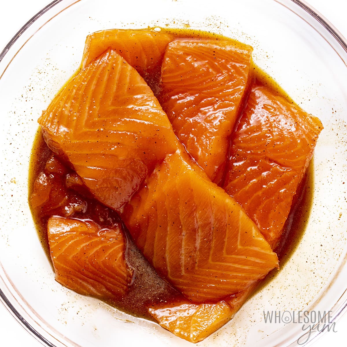 Raw salmon marinated in a bowl.