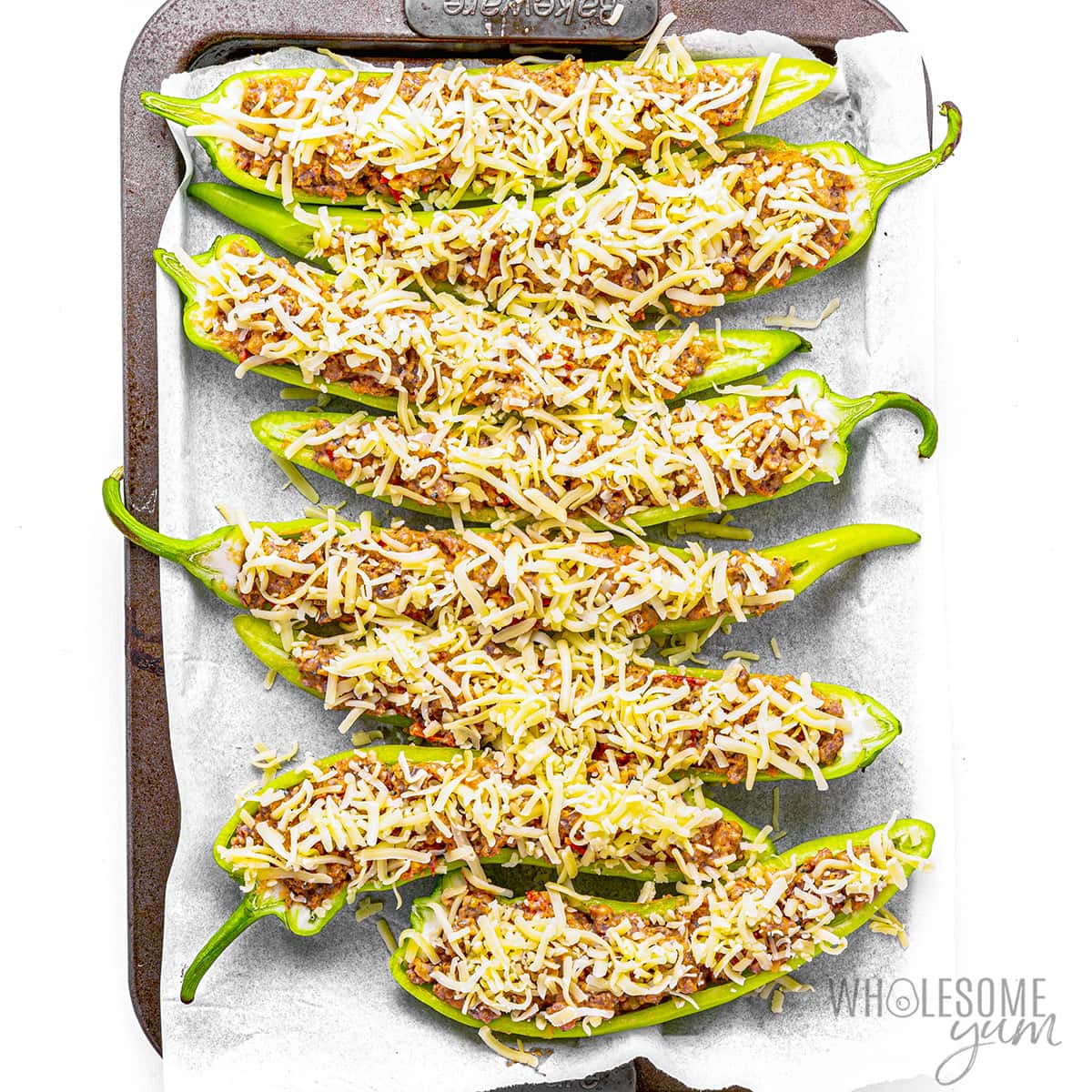 Sausage stuffed banana peppers topped with shredded cheese.