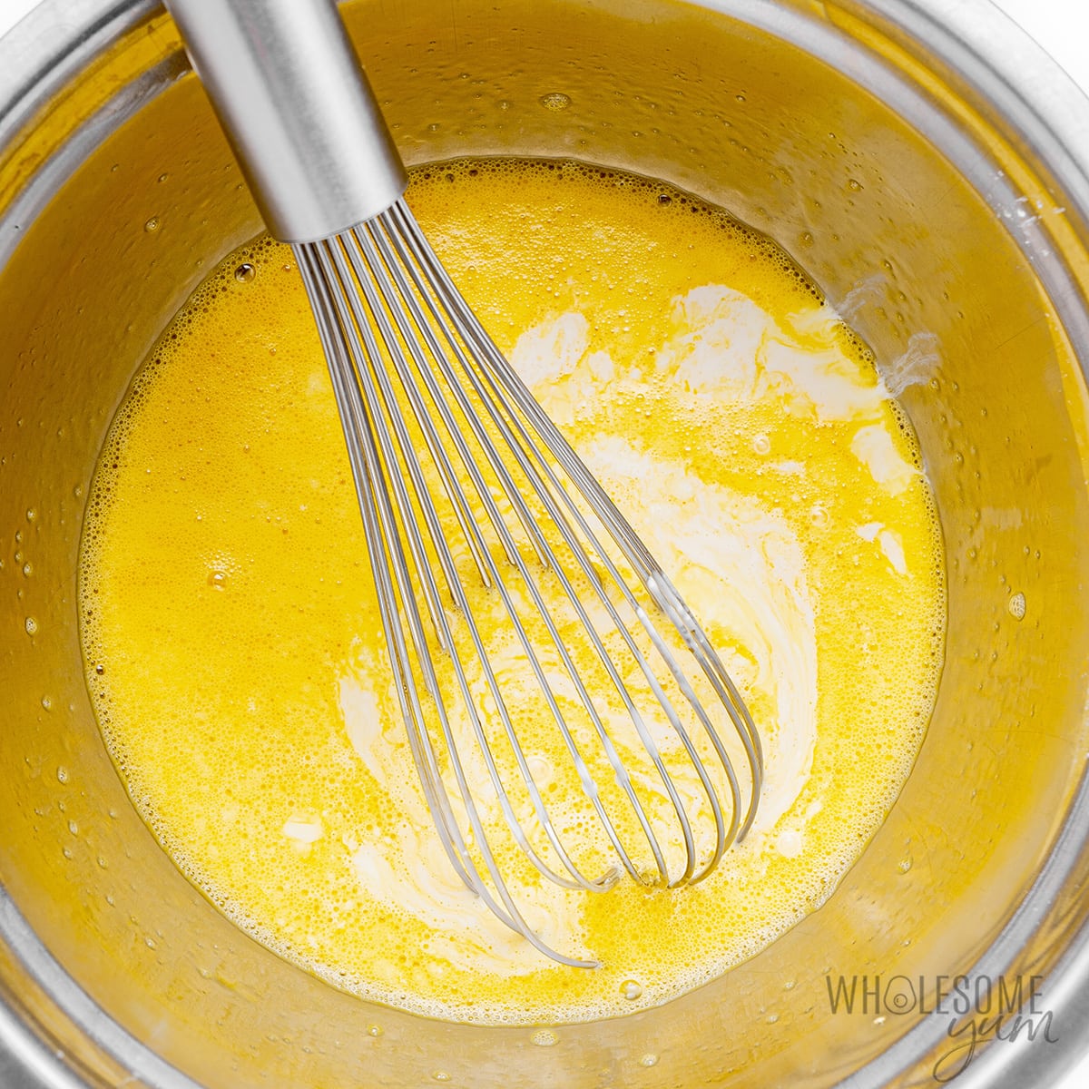 Eggs whisked in a bowl.