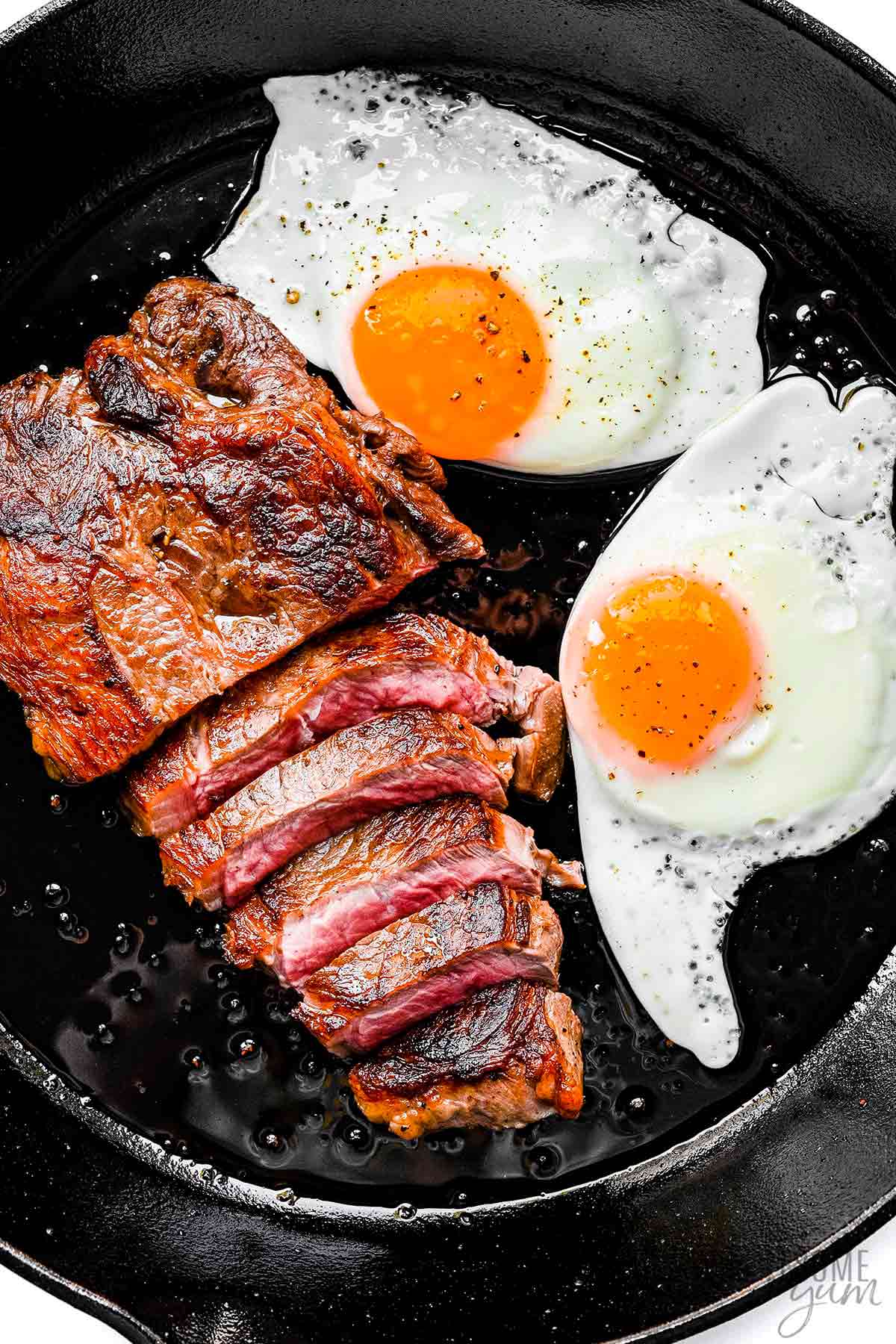 Steak and eggs in a cast iron skillet.