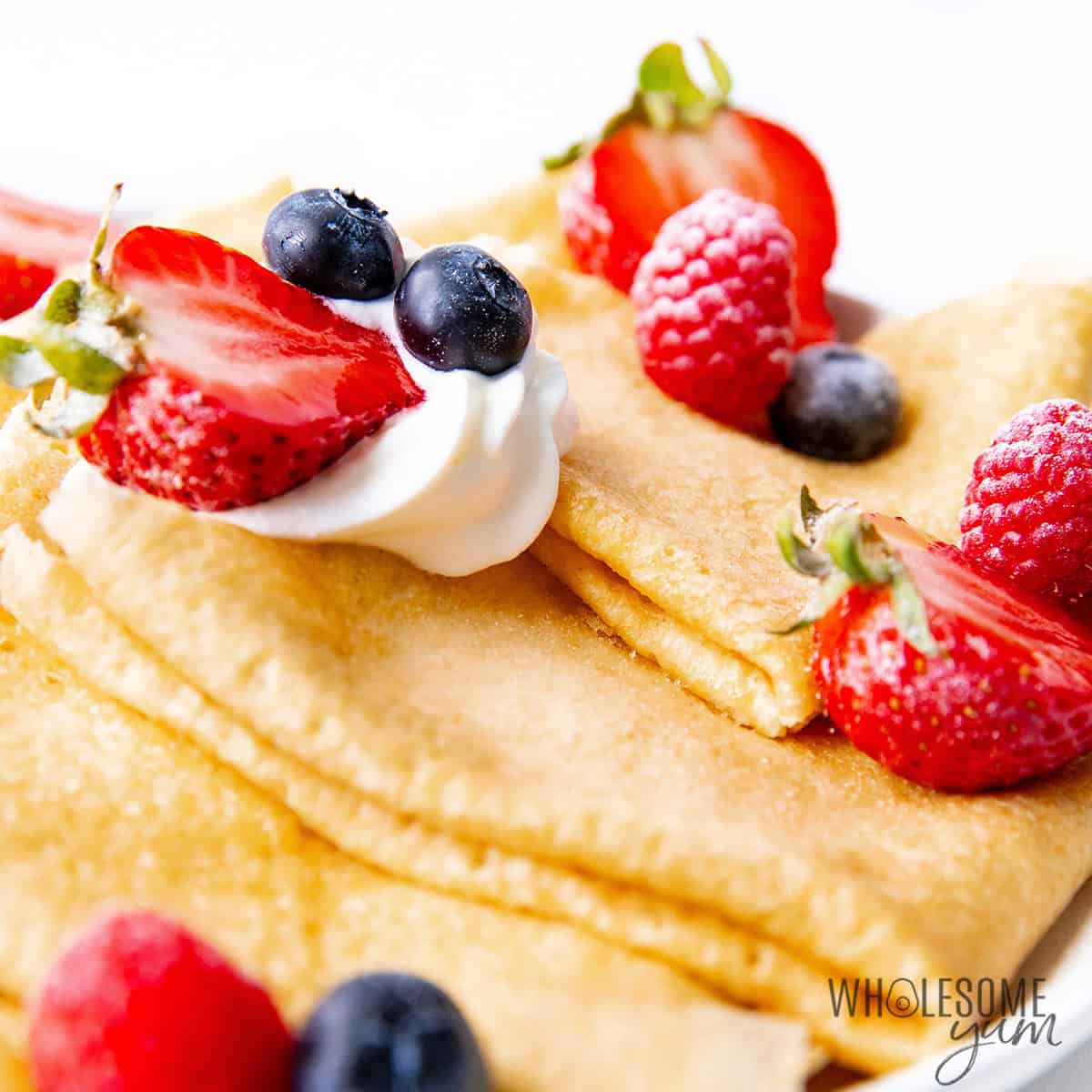Pile of almond flour crepes close up on a plate.