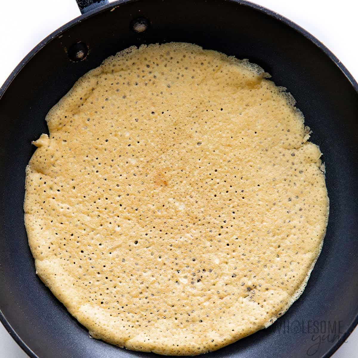 Flipped low carb crepe with golden brown surface.