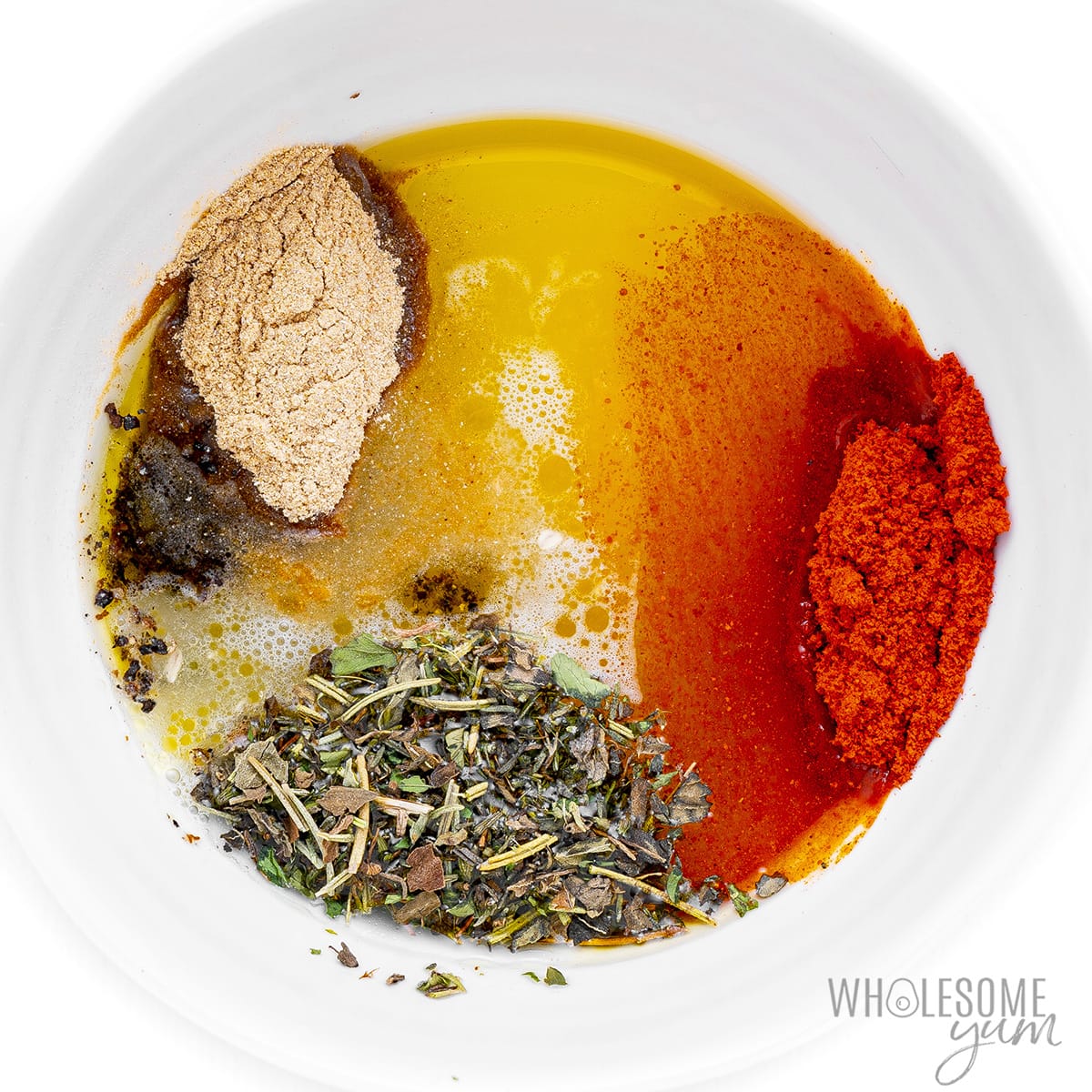 Spices mixed together in a bowl with oil.