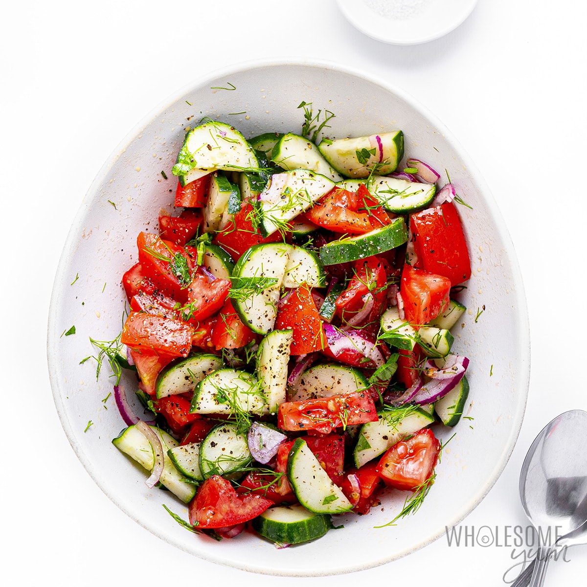Dressing drizzled on cucumber and tomato salad.