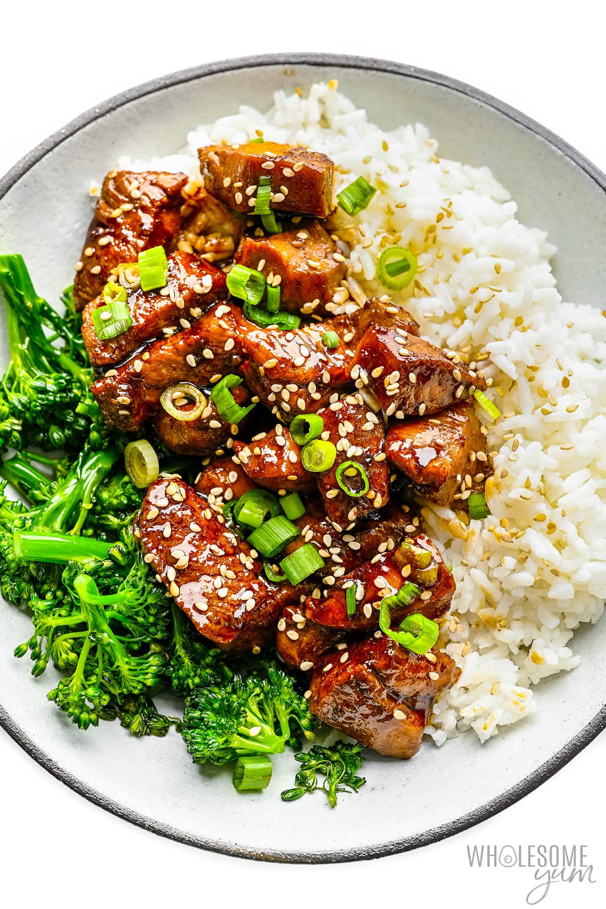 Chicken teriyaki plated with rice and broccolini.