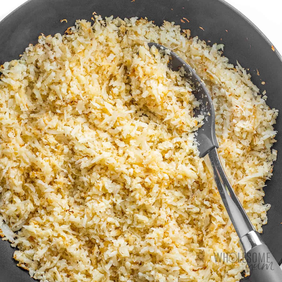 Sauteed cauliflower rice in a skillet.
