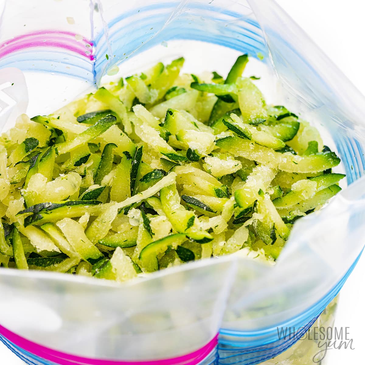 Shredded zucchini placed in a zip lock bag for freezing.