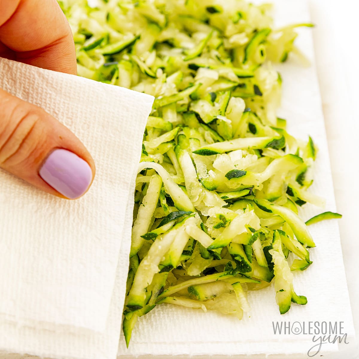 Shredded zucchini patted dry with a paper towel.
